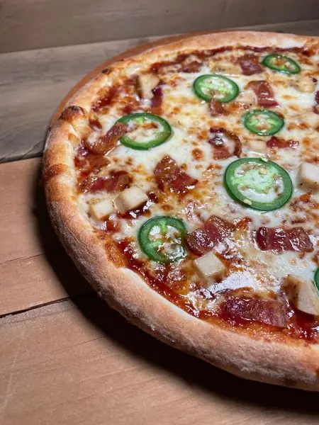BBQ pizza with jalapeno and diced meat, cooked in the wood oven