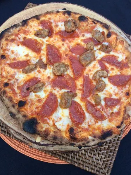 Pepperoni and sausage pizza on a woven mat